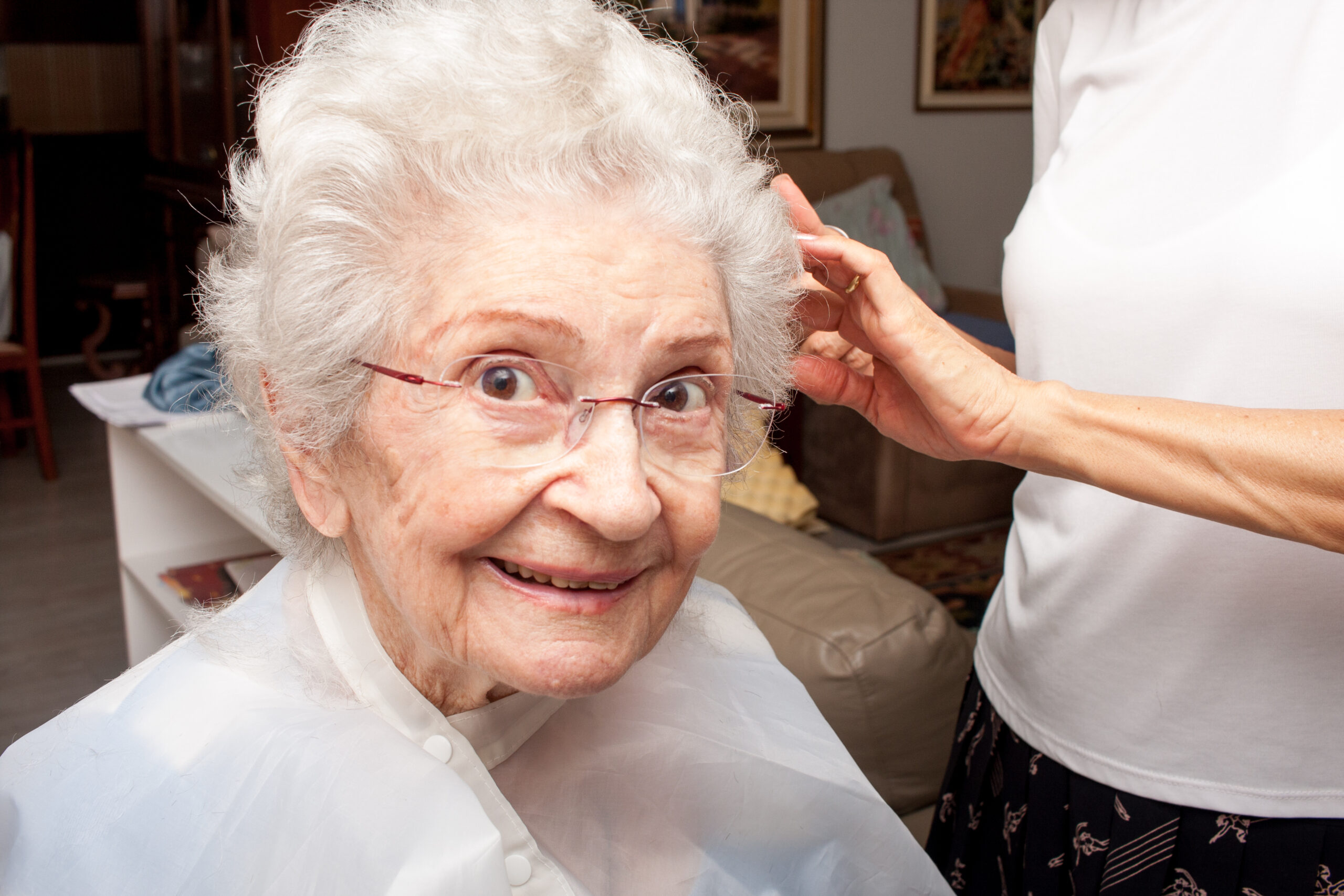 elderly lady getting a haircut in her own home
