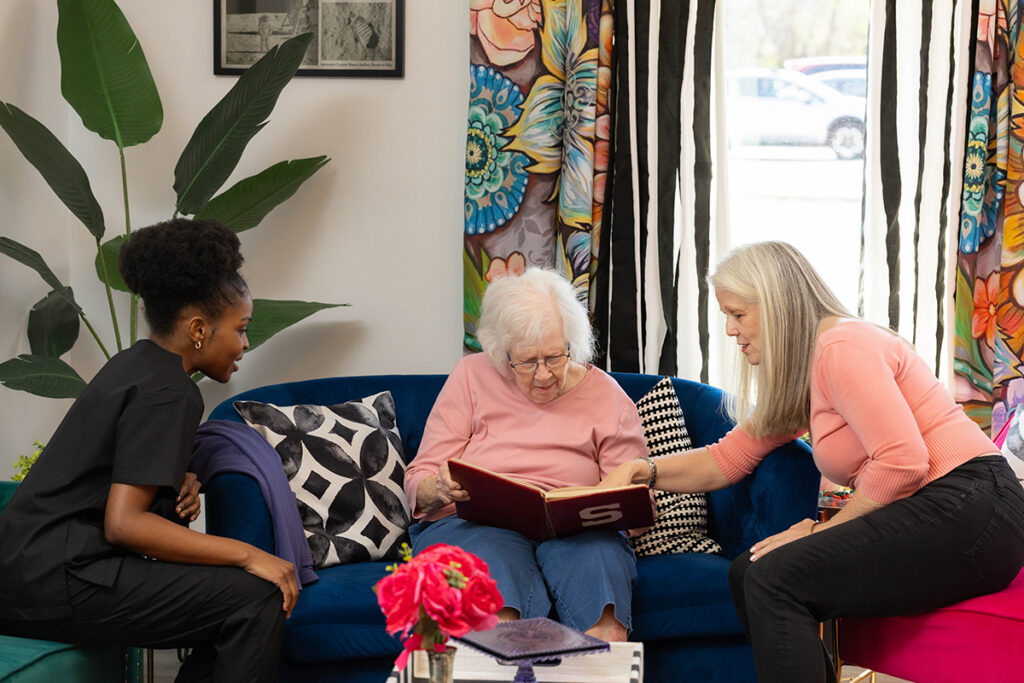 Caregivers providing memory care support for an elderly woman with Alzheimer’s in Oklahoma City