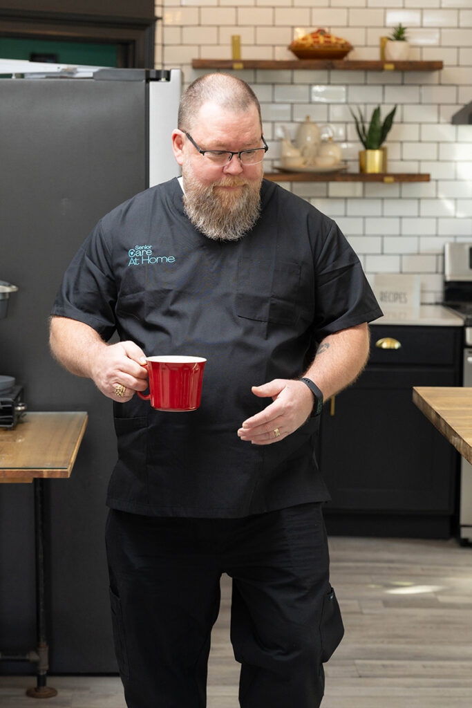 Professional caregiver providing home care assistance in a kitchen during an in-home care visit